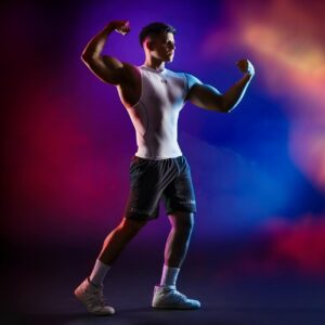 Muscular athlete flexing arms against colorful background showcasing strength and fitness.