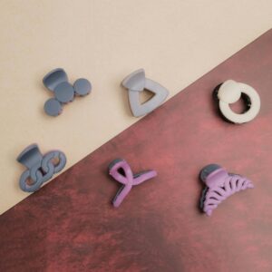 A variety of colorful hair clips arranged on a two-toned textured surface, showcasing modern accessory design.