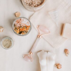 Serene flat lay of spa essentials including jade roller and bath salts for a calming skincare routine.